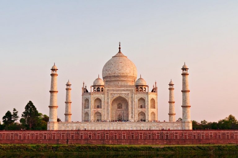 O Taj Mahal ao entardecer, visto da margem do rio Yamuna
