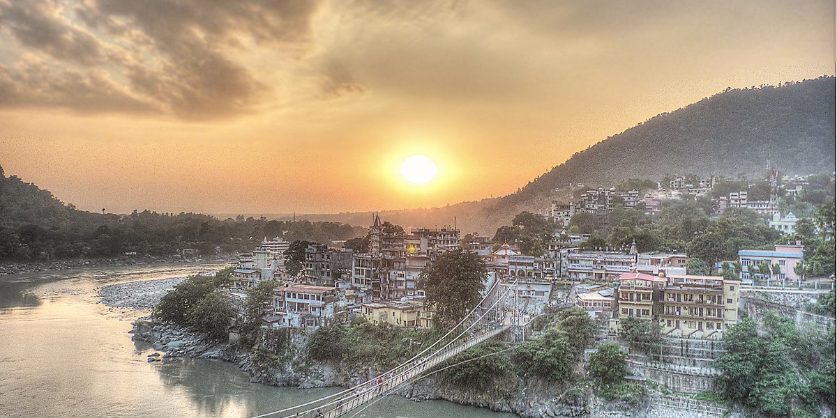 O pôr do sol sobre o Ganges e a ponte Lakshman Jhula, em Rishikesh